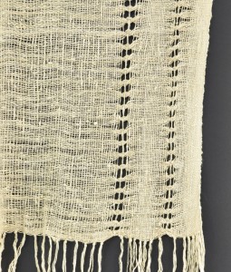 Groups of weft threads are crossed and held in place by needleweaving in a warp thread after the woven scarf comes off the loom.