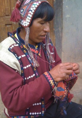 Chahuaytire man knitting a traditional multi-colored alpaca/wool hat. 