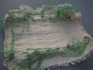 Cloth fully gathered, green threads tied. 